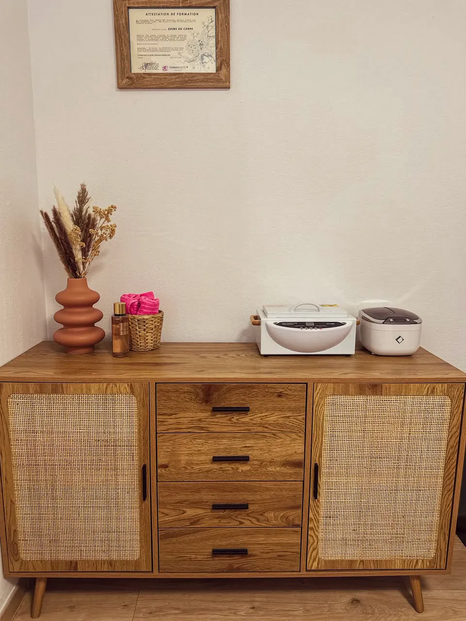 La commode en bois clair et le diplôme encadré du salon